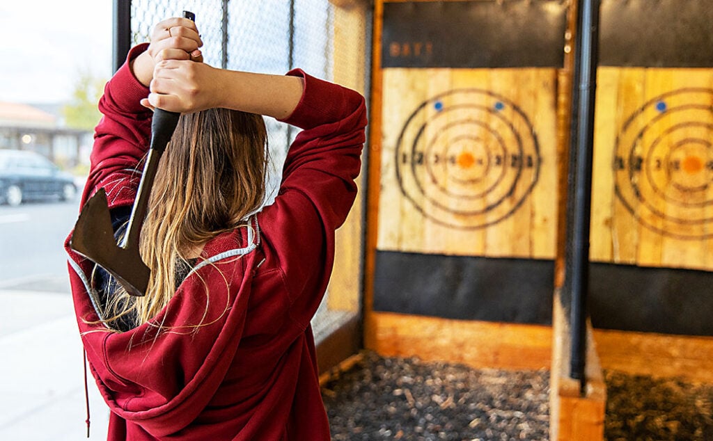 Girl throwing an Axe at a wooden target